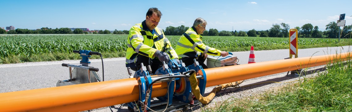 Mitarbeiter arbeiten auf der Baustelle an Gasleitungsrohren.